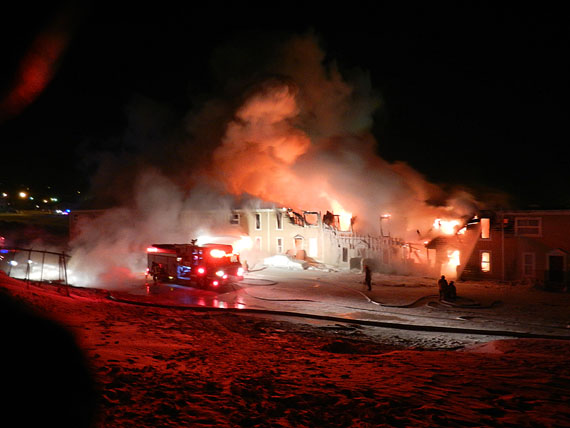 Flames eat their way through the 300-block of rowhouses at Iqaluit’s Creekside Village during the early morning hours of Feb. 27. Andrew Papatsie, 27, and Connie Papatsie, 25, died in the fire, which consumed 22 housing units and displaced 83 people. (FILE PHOTO)