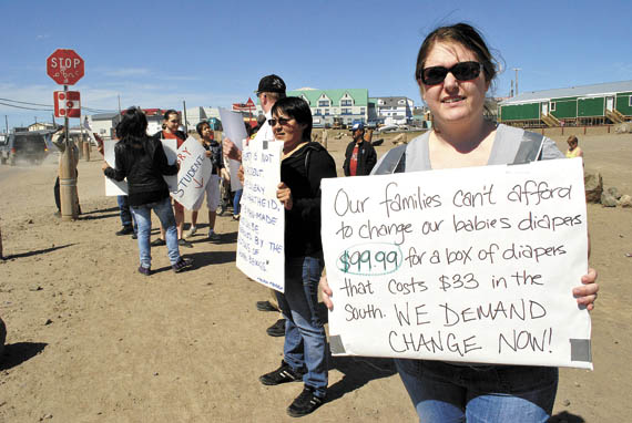 Inspired by the Feeding My Family Facebook group, food price protestors stand across the street from Iqaluit’s Northmart store on Aug. 25. (FILE PHOTO)