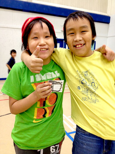 Phillip Okatsiak, posing with his friend Kevin Mikiyungiak, holds an African bracelet he won as a prize. (PHOTO COURTESY M. CRANDALL)