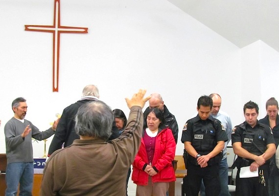 Members of the Full Gospel and Anglican congregations in Kangirsuk say a prayer with police March 6 at a memorial service for Steve Dery, a constable with Nunavik's police force who was killed March 2 in Kuujjuaq when he responded to a domestic violence call. Dery served in Kangirsuk in 2009. Read more about the memorial on Nunatsiaqonline.ca. (SUBMITTED PHOTO)