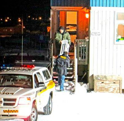 Police carry boxes out of House 1080 on Chopper Crescent in Kuujjuaq March 3, about 22 hours after a call to police about a domestic dispute, which resulted in the death a young Kativik Regional Police Force constable and a Kuujjuaq man. Another police officer was wounded during the incident. (SUBMITTED PHOTO)