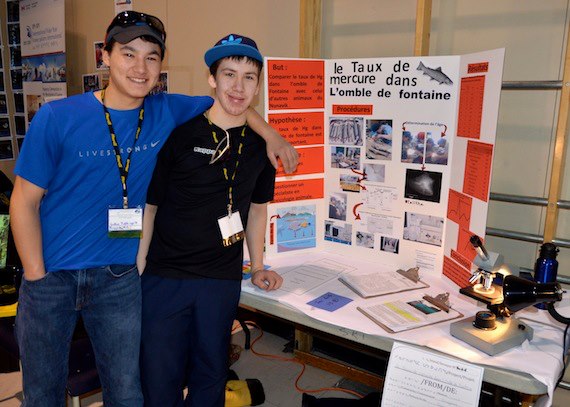 Lukasi Tukkiapik and Jeremy Davies of Kuujjuaq stand next to their exhibit on the level of mercury in brook trout,