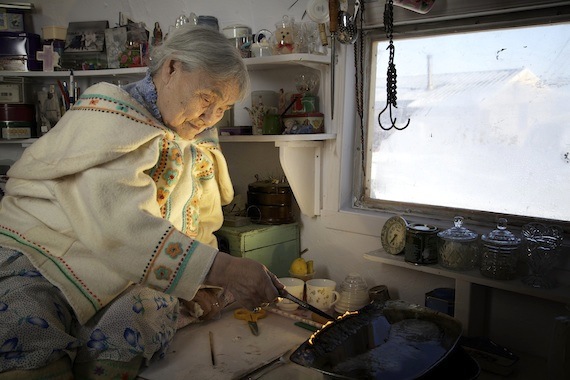 Qapik Attagutsiak, 92, of Arctic Bay tends a qulliq April 20. (PHOTO BY CLARE KINES)