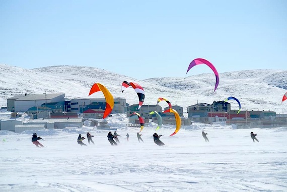 Kite-skiers speed in front of the sea ice in Kangiqsujuaq where the Nunavik kite-ski championship took place earlier this month. (PHOTO BY GEORGE ANAUTAQ PIRLUTUUT)
