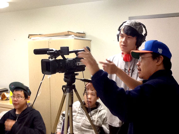 Innosar Issakiark picks up some tips for recording from Eric Anoee Jr.. Issakiark and the other members of the Arviat Film Society were interviewing youth on their perspectives on bullying during one of many evening workshops. (FILE PHOTO)