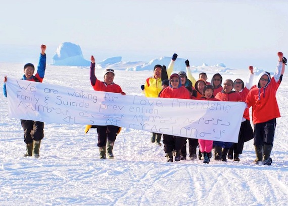 Some of the participants in Qikiqtarjuaq's suicide prevention walk arrive in the community May 27, holding a banner that reads