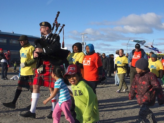 Under sunny, cloudless skies a piper leads a march for cancer survivors June 14 in Puvirnituq. (PHOTO BY ALAIN CLOUTIER)