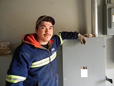 Daniel Gadbois, 29, stands by one of the many electrical boxes he set up in Kuujjuaq's future suites hotel. (PHOTO BY JANE GEORGE)