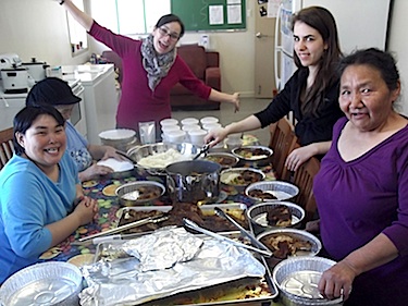 Alicia Argutak, in back, and others at the Igavik Club in Umiujaq prepare portions of food which are sold for $2 a portion. (PHOTO COURTESY OF IGAVIK CLUB)