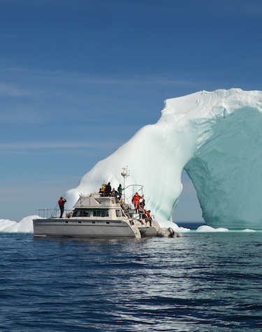 Johnny Adams' Arctic Cruises expedition catamaran, the Alara, stops with the boatload of visitors from the UK beside an iceberg floating just off the coast of Akpatok Island. (PHOTO BY ISABELLE DUBOIS/NUNAVIK TOURISM)