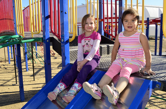 Little Ava and Kaya of Iqaluit enjoy sliding at the playground behind Nakasuk School in Iqaluit Aug. 8, when the day-time temperature soared to 21 C by 3:00 p.m., making it one of the warmest days this year in the city. Environment Canada forecasts cooler weather for Aug. 9, with a high of 15 C, overcast skies and a 60 per cent chance of showers in the evening. (PHOTO BY JIM BELL)