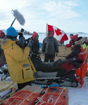 Two members of the Watchers of the North crew, Steph Weimar and Chris Yapp (left,) film a snow machine repair. (PHOTO COURTESY OF WATCHERS OF THE NORTH)
