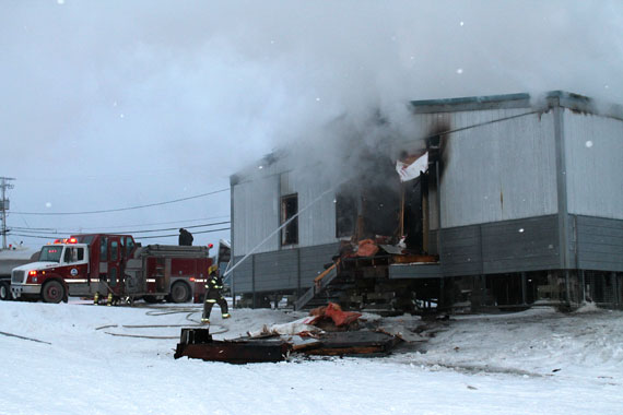 Igloolik firefighters work to control a fire that broke out early Oct. 24 at the Inulirivik Building, also known as the 