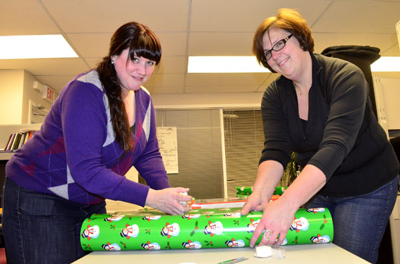 Jessica Dewar and Melanie Abbott, volunteers with Iqaluit's Angel Tree project, wrap Christmas presents Dec. 18. They and many other volunteers have been wrapping gifts that they will distribute Dec. 21 to needy families around Iqaluit. This year, the Angel Tree group's fundraising efforts triggered a small avalanche of donations from many sources, including First Air, the Legion and the Frobisher Inn. (PHOTO BY JIM BELL)