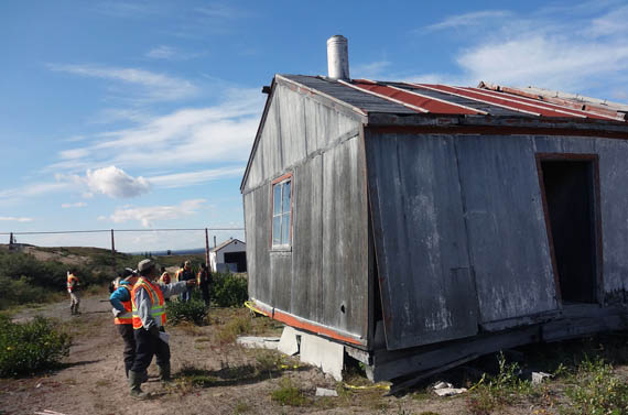 Arviammiut visitors to Ennadai Lake look at one of the weather station’s dilapidated buildings during a trip to the site this past summer. (PHOTO COURTESY OF AAND)