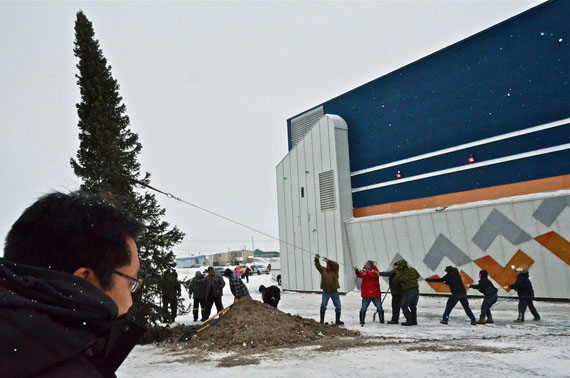 Kuujjuaq mayor Tunu Napartuk, left, watches as municipal staff and volunteers help to hoist up the town's Christmas tree Dec. 5, which will stand on display for the holidays outside the northern village office. This is the second year the town has harvested a tree from a nearby area locals call 