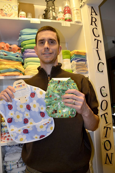 Brad Chambers of the new Apex business Arctic Cotton holds up a cloth bib and diaper. Their new business started up in late 2013, and in years to come they hope to replace disposable diapers with their reusable cloth and cotton diapers. (PHOTO BY DAVID MURPHY)