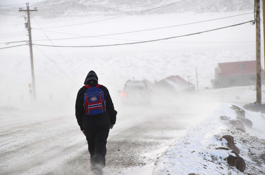 The worst may be over, but Iqaluit is still in the grip of fierce weather Jan. 9. Here, a man walks down the road overlooking Happy Valley next to Joamie School in -18 C temperatures, -33 C with the wind chill. That's after a Jan . 7 blizzard that caused damage to buildings, vehicles and street signs in the city. (PHOTO BY DAVID MURPHY)