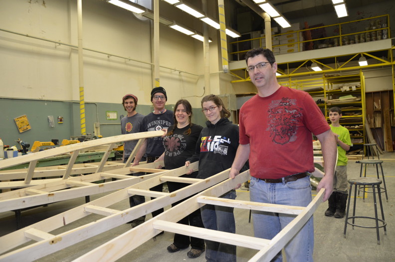 From left to right: Aiden Stanley, Jeremy Debicki, Tanya Bjornson, Julia Landry and Patrick McDermott hold up handmade kayaks at a workshop at Inuksuk High School Feb. 19. While kids are off school this week for a winter break, it’s professional development week for teachers across Nunavut. “Teachers can choose an activity or do something to improve themselves professionally,” said Landry, a math teacher at Inuksuk. At the workshop, Eric McNair-Landry and Katherine Breen — who both travelled 1,000 kilomtres from Qikiqtarjuaq to Cape Dorset on kayaks this past summer — led the kayak-building workshop. The group will make five kayaks which will be given to the school for the students to use in the classroom, and on the water. (PHOTO BY DAVID MURPHY)