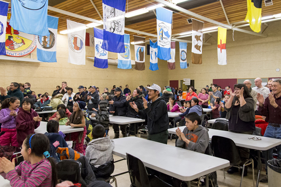 Residents of Kugluktuk rise to their feet to applaud their MLA, Nunavut Premier Peter Taptuna, at the Kugluktuk recreational complex Feb. 19. Taptuna and all other MLAs and cabinet ministers are holding a full caucus retreat in Kugluktuk this week to reach agreement, behind closed doors, on a new mandate statement for the government. The hamlet used the the opportunity to invite the premier, MLAs and the community to a feast and celebration Feb. 20. (PHOTO BY JESSE AJAYI) 