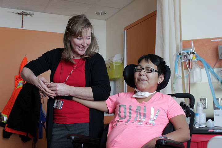 Physical therapist Sue Ritonja gentle straightens out the fingers of Malaya Roberts' right hand, which have become stiff and unusable since the accident. Ritonja visits Roberts weekly to administer myofascial release therapy, which involves applying pressure to Roberts' muscles to release tension in the hope of restoring some strength and movement to her upper body. (PHOTOS BY LISA GREGOIRE)