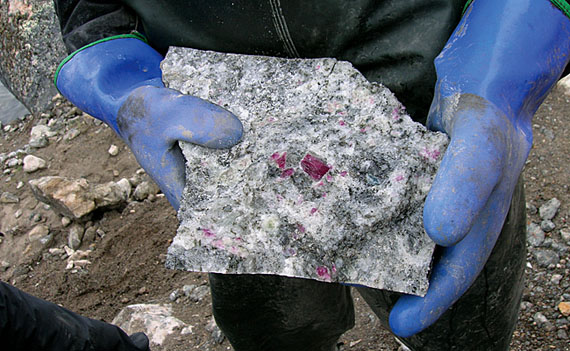 A worker with True North Gems holds a piece of corundum ore that's studded with crystals. (PHOTO COURTESY OF TRUE NORTH GEMS)