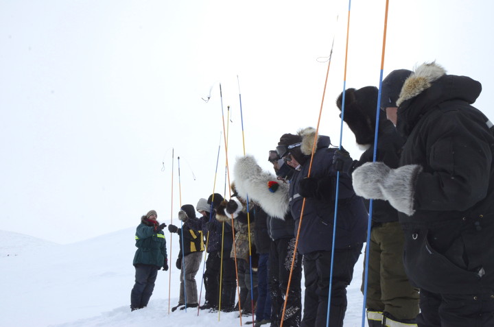 Parks Canada resource management officer Tyler Harbidge, left, gives instructions to nine first-year Nunavut Arctic College Environment Technology Program students April 4 near Crazy Lake, about 13 kms from Iqaluit. Harbidge was invited to ETP's annual winter field camp, which ran April 2 - 9, to train students in avalanche awareness. Parks Canada is hoping the training, and familiarity with equipment, will allow those students to take part in future emergency searches once they take jobs throughout Nunavut. The ETP field camp included other survival training as well as exposed students to field science, in this case, freshwater research at Crazy Lake. Read more about the camp later on nunatsiaqonline.ca. (PHOTO BY DAVID MURPHY) 