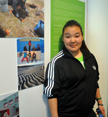 Maggie Irqumia stands next to one of her photos that appears in the exhibit. (PHOTO BY SARAH ROGERS)