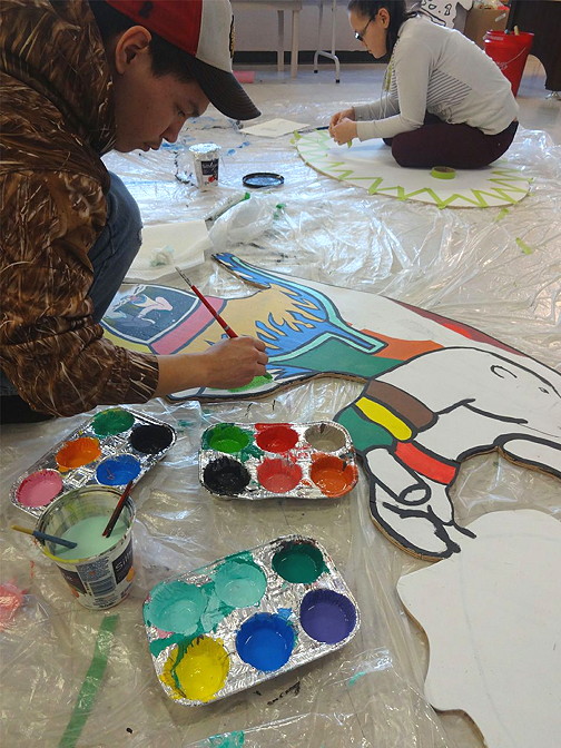 Joe Sabourin, foreground, and Caryn Angidlik, paint their plywood canvases in Rankin Inlet. (PHOTO BY PASCALE ARPIN)