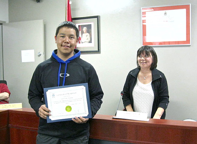 Sean Noble Nowdluk of Iqaluit received a certificate of recognition from the city May 13 for his “compassion and selfless act” of withdrawing from the Toonik Tyme festival’s Iqaluit-Kimmirut snowmobile race April 19 to take an injured racer back to Iqaluit. Deputy Mayor Mary Wilman, right, presented the 18-year-old with the award at a city council meeting. (PHOTO BY PETER VARGA)