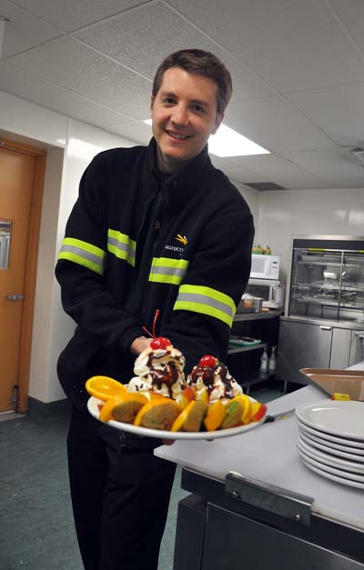 A Meadowbank employee shows off his sundae creation during the cafeteria's popular 