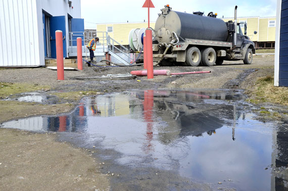 Can't you smell that smell? Sewage spilled onto the property of the Grind and Brew cafe in Iqaluit on the afternoon of June 18. Brian Twerdin, co-owner of the Grind and Brew, noticed the leak and called the City of Iqaluit dispatch service immediately. “No, not good for business,” Twerdin said. The stench has wafted throughout the surrounding neighbourhood and a thick black puddle sits in front of the cafe. The cause of the sewage leak is unknown but Twerdin said a city crew responded quickly. “I assume they’re trying to pump it out,” he said. Iqaluit's director of public works, Keith Couture, said at a May 20 city council meeting that the city must replace its sewage lines. Couture said at the time that Iqaluit's sewer system has never been upgraded, and replacing the city's entire sewer system would cost upwards of $30 million. (PHOTO BY DAVID MURPHY)

