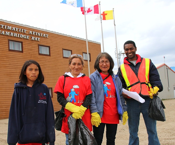 A couple dozen Cambridge Bay residents grabbed a free T-shirt, some gloves and garbage bags, sprayed themselves with mosquito repellent and fanned out across the community July 16 to clean up a winter's worth of garbage and debris. All volunteers were eligible to enter a draw to win two tickets to anywhere Canadian North flies. Here are a few who came out to help, from left: Kyla Komaksiut, Eva Mingilgak, Jeannie Komaksiut and Wayne Gregory. (PHOTO BY KELCEY WRIGHT)