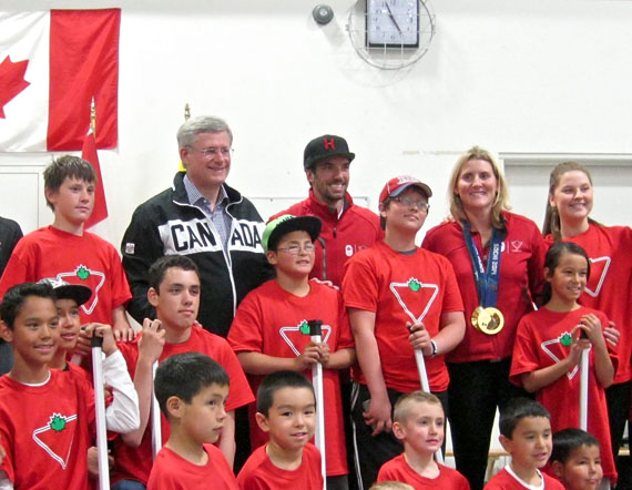 Prime Minister Stephen Harper, in black, poses for a team photo with Canadian Olympic gold medalists Charles Hamelin and Hayley Wickenheiser, to his left, at a special event sponsored by Canadian Tire Corp. Harper joined the kids and athletes for a quick game of floor hockey with his wife Laureen, who refereed. (PHOTO BY PETER VARGA)