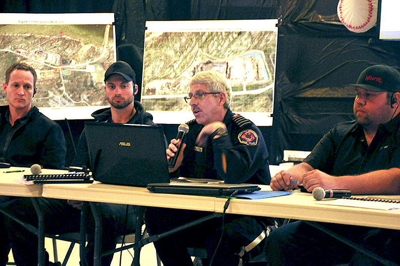 About 50 people turned up to an evening public meeting in Iqaluit Aug. 25 to hear how the City of Iqaluit hopes to extinguish its dump fire, which has been burning for nearly 100 days. Residents expressed concerns and frustration, but also relief and gratitude that the fire will soon be put out. Iqaluit Fire Chief Luc Grandmaison said he expects to begin dousing the smouldering dump with sea water on Aug. 27 and that residents should not be alarmed when they see plumes of white smoke billowing from the site. Above, officials answer questions at the meeting. From left: Matthew Hamp, Iqaluit director of engineering, Eric Jacobsen, from Tower Arctic Ltd., Grandmaison and Ryan Stambaugh from Hellfire Suppression Services Ltd. Tower Arctic and Hellfire have been contracted to help with the project. See story later on nunatsiaqonline.com. (PHOTO BY THOMAS ROHNER)
