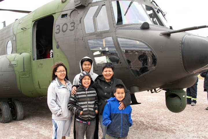Baker Lake residents got up close and personal with a pair of brand new Canadian Armed Forces Chinook helicopters Aug. 12 on their way from Petawawa, Ont., to Alert, Nunavut on a test mission. CF members want to make sure the choppers' GPS systems and other equipment are functioning properly. The Chinooks have a dry weight of 25,000 lbs, can lift up to 54,000 pounds and can fly with a maximum speed of about 180 knots. The big birds attracted lots of attention from Baker Lakemiut so CF members allowed residents to have a peek inside. Here are a few of the curious: Frances Kaluraq, far left, Keasten Avaala, back row, Andre Avaala, middle front, Sarah Avaala, the proud mom, and young Wes Avaala. (PHOTO BY VALTER BOTELHO-RESENDES)