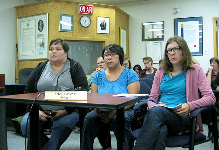 Iqaluit citizens’ group Iqalummiut for Action, represented by Christa Kunuk, Romani Makkik, and Sarah McNair-Landry (left to right), listen to how the city is addressing their concerns about the 12-week-old dump fire at a crowded city council meeting, Aug. 12. (PHOTO BY PETER VARGA)