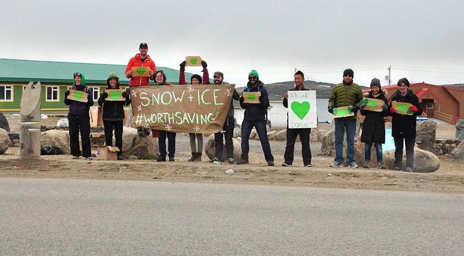 A small group of Iqalungmiut hold up signs in front of the elder's centre Sept. 20 to join in a global campaign to encourage world leaders meeting to discuss climate change at the United Nations in New York this week to curb use of fossil fuels and cut CO2 emissions. (PHOTO BY THOMAS ROHNER)