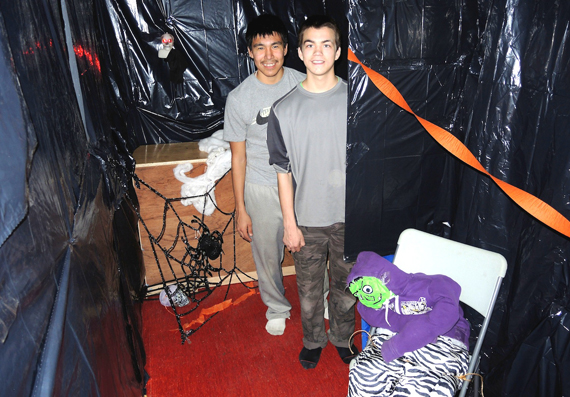 Come on in and prepare to be scared: Luukasi Gordon (left) and Kevin Tukkiapik (right) pose near one of the long dark hallways inside the haunted house that they helped make at Kuujjuaq's Uvikkait Dome Youth centre. Staff created the scary house for people in the community as a lead-up to Halloween, Oct. 31. (PHOTO BY ISABELLE DUBOIS)