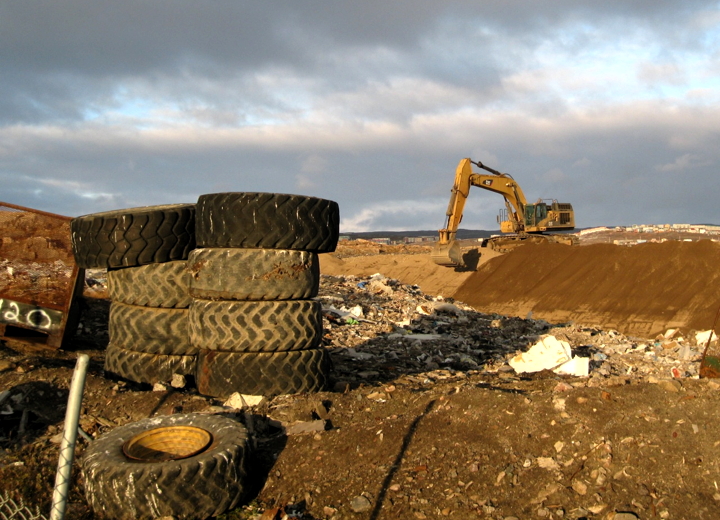 An excavator spreads sand over a garbage heap that smouldered all summer at Iqaluit’s dump, formerly known as the “dumpcano,” in this photo taken Sept. 27. (PHOTO BY PETER VARGA)