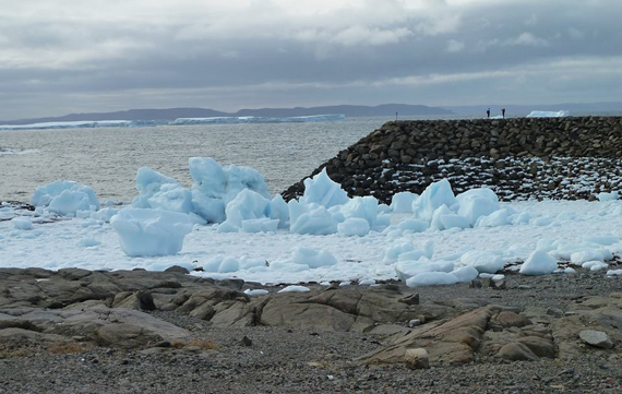 During low tide, icebergs become grounded along the shoreline and quickly break up, like this one pictured at Quaqtaq’s marine infrastructure last week. (PHOTO BY JOHNNY OOVAUT)