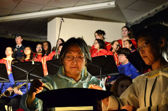 Peepeelee Pijamini and Kovean Pitseolak tend the qulliq at Remembrance Day observances on the morning of Nov. 10 at Inuksuk High School in Iqaluit. Students honoured Canada's war dead with brass-band music, drum-dancing, choral pieces and recitations. (PHOTO BY JIM BELL)