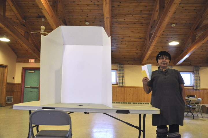 Marie Michael, community liaison officer for Iqaluit, displays the three ballots local beneficiaries will cast today at Iqaluit's parish hall polling station: one for the three contenders in the Nunavut Tunngavik Inc. vice-presidential race; one for the six contenders in the Qikiqtani Inuit Association race for presidency; and one for two contenders for QIA's Iqaluit community director position. Baffin residents will also vote for QIA community directors in Sanikiluaq, Kimmirut, Igloolik and Hall Beach. Candidates for community director in Grise Fiord, Clyde River and Pond Inlet were all acclaimed before the election. Polls across Nunavut are open from 10 a.m. to 7 p.m., local time, Dec, 8, with results expected to be posted on the websites of QIA and NTI a few hours after that. (PHOTO BY THOMAS ROHNER)