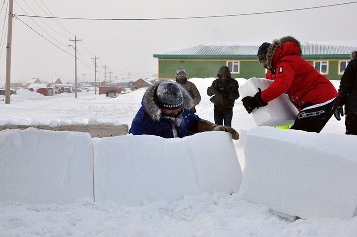 Master igloo builder Solomon Awa (blue parka) led a handful of Iqalungmiut in the building of a traditional snow house outside the Unikkaarvik Visitors Centre in Nunavut's capital Feb. 15. The construction lesson, hosted by Nunavut Tourism, is one of many events hosted by the visitor's centre throughout the winter including a weekly Arctic/Inuit movie night on Thursdays and Inuit Art experiences with local artists on Saturdays. (PHOTO BY THOMAS ROHNER)
