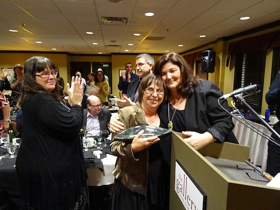 Sheila Levy, founder of the Kamatsiaqtut Help Line 25 years ago, who continues to volunteer for the service, receives a qulliq from Kamatsiaqtut's president Charlotte Borg Vander Velde at the group's March 28 fundraiser in Iqaluit. (PHOTO BY JANE GEORGE)