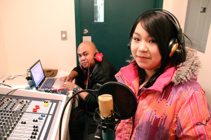 Yellowknife-born rapper Godson, left, helps Cambridge Bay's Tamieka Oakoak, 12, record her new song Feb. 28 in the community hall. About 10 youth attended a two-day music workshop put on by Godson last weekend. (PHOTO BY KELCEY WRIGHT)