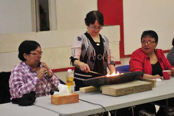 Minnie Etidloie of Kangisujuaq lights the qulliq at Arnaliat Nipingit 2015, Nunavik's second regional conference hosted by the Saturviit Inuit Women’s Association in Akulivik March 2-6. The event serves as a forum for Nunavimmiut women to gather and share views on employment, education, family challenges, parenting, violence and addiction. Participants will also identify five actions to be presented to the 59th session of the UN Commission on the Status of Women in New York, to be held March 17. (PHOTO BY ROBBIE PAQUIN)