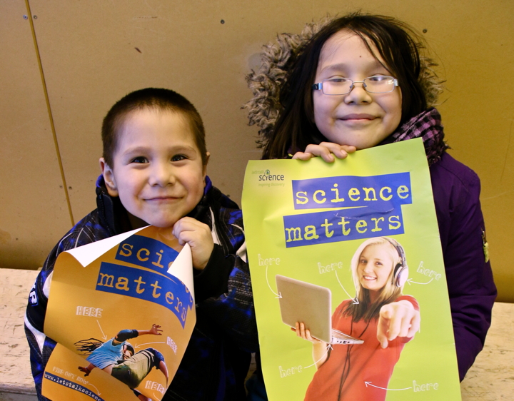 Oliver Maksagak, five, and Avi Maksagak, 10, show off their posters after the March 12