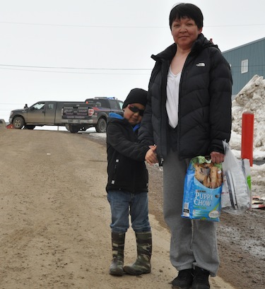 Monica Nuqingaq and her son, Mosha, head home to their two dogs shortly after the standoff ended. (PHOTO BY THOMAS ROHNER) 