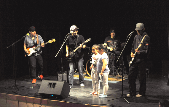Arviat's Got Talent: Abe Eetak, centre, who performs under the stage name Agaagtoq, entertains a crowd at Arviat's John Arnalukjuak high school May 28. Eetak played with fellow performers Calvin Pameolik, left, Michael Shamee (on drums) and Guther Kablutsiak, right, along with some back-up vocals from a couple of young audience members. (PHOTO BY ERIC ANOEE)